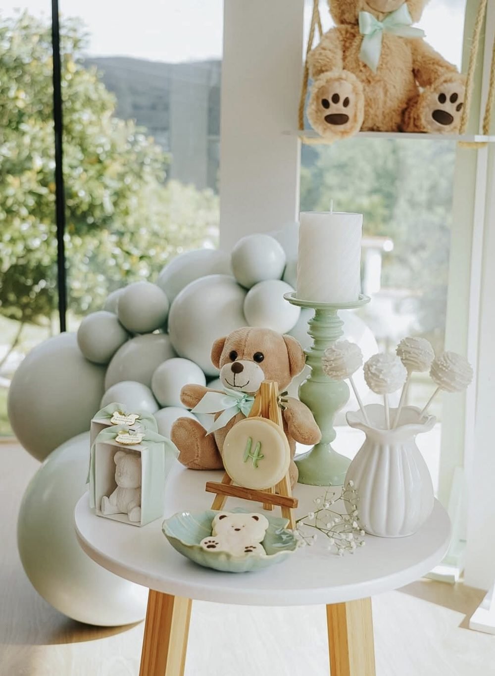 Mesa de doces com ursinho e balões verde-água